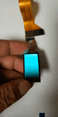 1.5-inch flexible AMOLED display shown live in hand with a color gradient test on screen and folded FPC cable.