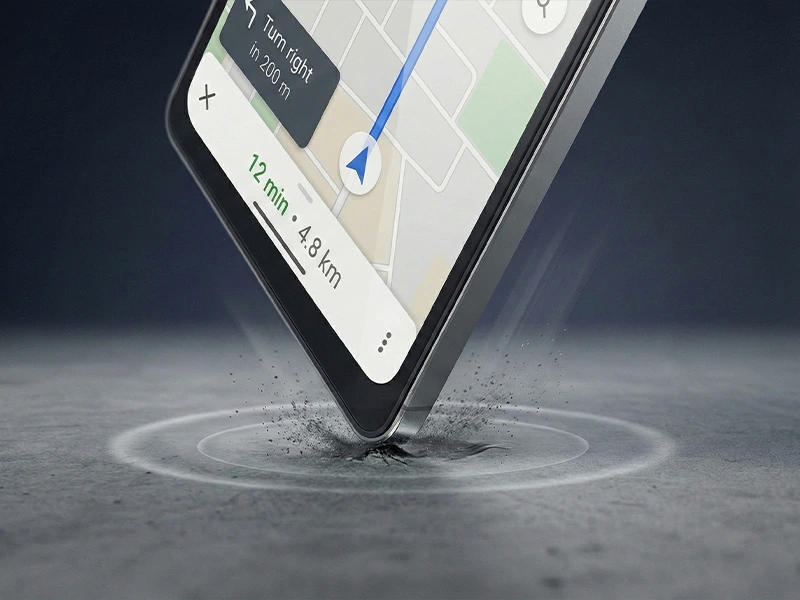 Smartphone with a GPS navigation interface hitting a concrete surface on its corner, with dust splash and impact ripple effects.